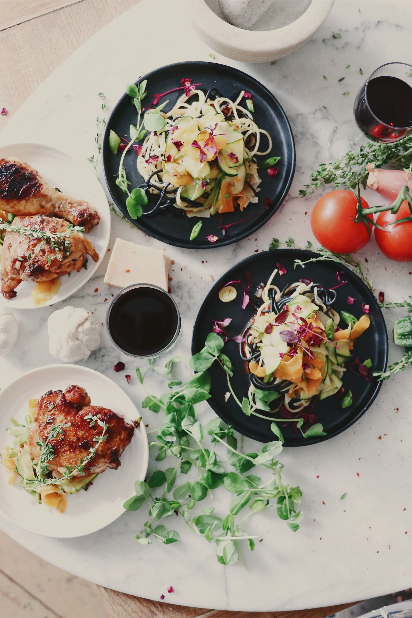 Plated dishes and fresh ingredients on a marble table